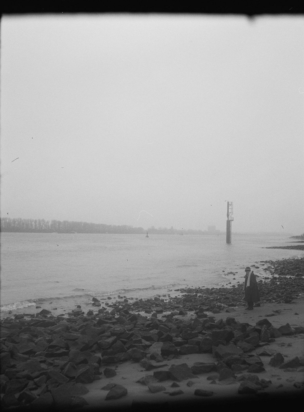 Old lady on the beach in Hamburg on a cold day. Shot on Ilford HP5 Plus